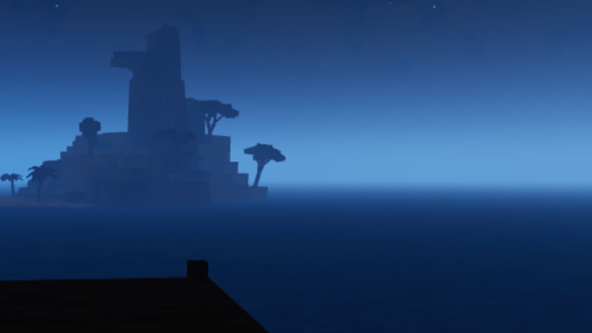 The beach at night with an island in the background.